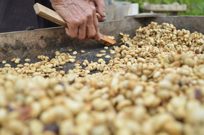 Cropped hands selling peanuts in market