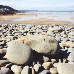 Close-up of pebbles on beach against sky