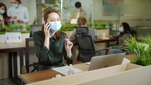 Businesswoman wearing mask working at office
