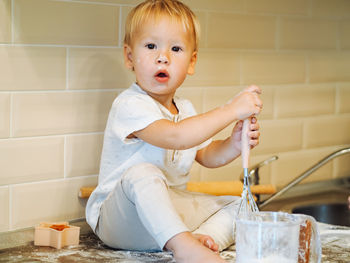 Portrait of cute baby boy sitting at home