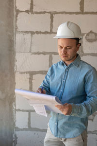 Rear view of man standing against wall