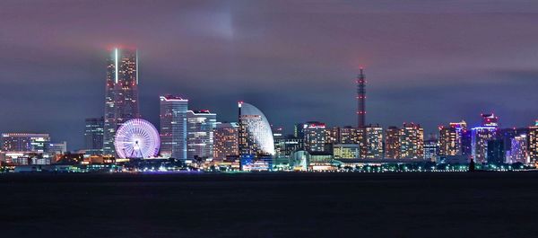 Illuminated buildings against sky at night