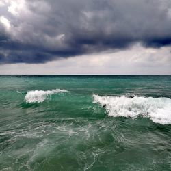 Scenic view of sea against storm clouds