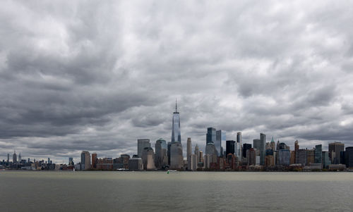 Modern buildings in city against cloudy sky