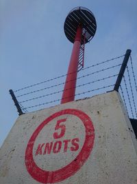 Low angle view of road sign against sky