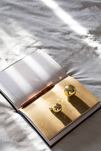 Open notebook, pen and sparkling christmas balls on bed. new year goals. 