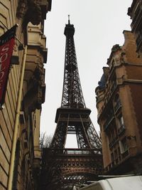 Low angle view of eiffel tower by buildings