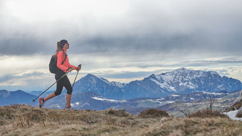 A nordic walking girl walking alone in the mountains