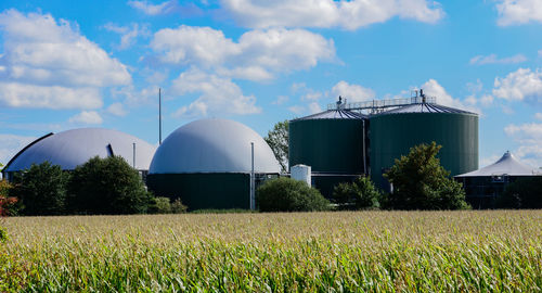 Industry on field against sky