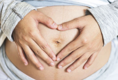 Midsection of woman touching heart