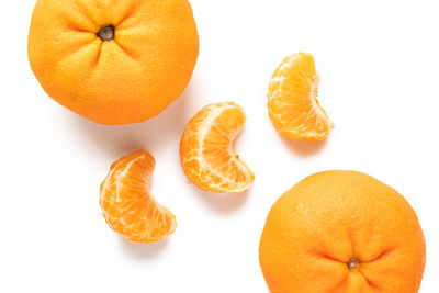 Close-up of orange slices over white background