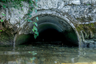 Water flowing through rocks in tunnel