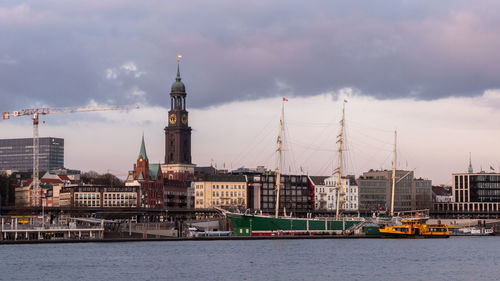 Sailboats in sea against buildings in city