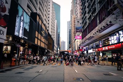 People on street amidst buildings in city