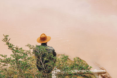 High angle view of man sitting by water