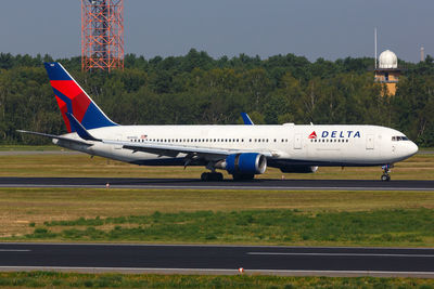 Airplane on airport runway against sky