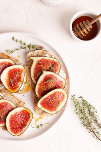 Breakfast with sweet bruschettas with figs and honey on a white plate