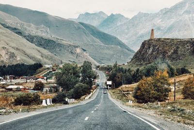 Road by mountains against sky