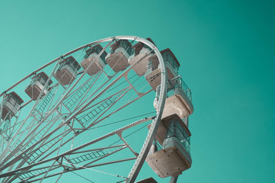 Low angle view of ferris wheel against clear blue sky