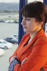 Thoughtful young woman looking through window