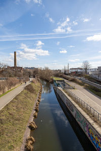 Scenic view of river by buildings against sky