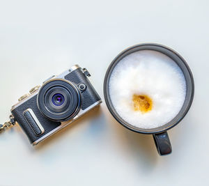 Cups of latte and camera on a white background.