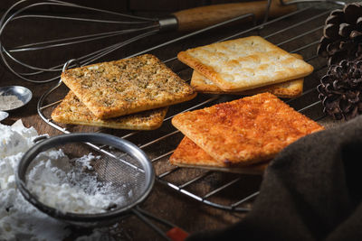 Square dry crackers biscuit on a wooden table. wooden texture dark background. snack dry biscuits