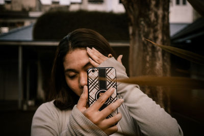 Young woman using mobile phone outdoors