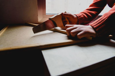 Close-up of hand holding book on table