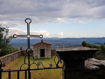 Cross by building against sky