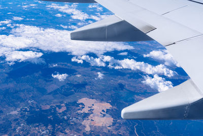 Aerial view of clouds over airplane wing