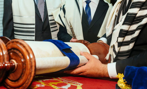 Midsection of lawyers holding document at desk