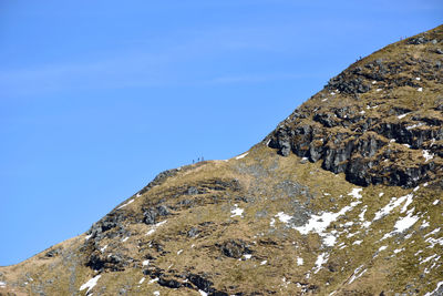 Low angle view of mountain against blue sky