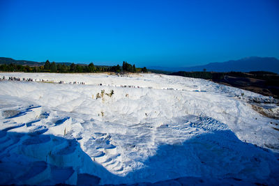 Scenic view of snowcapped landscape against blue sky