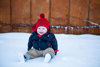 Cute boy in warm clothing on snow