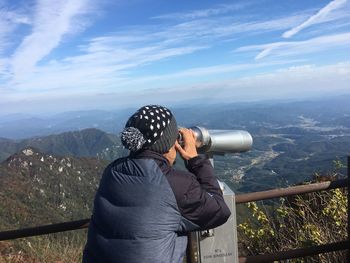 Man photographing on mountain against sky