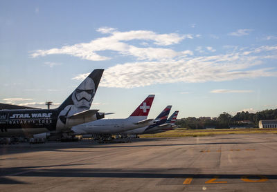 Airplane on airport runway against sky