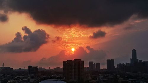 View of city against cloudy sky during sunset