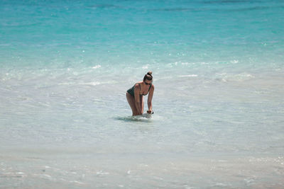 Rear view of woman standing in water