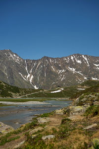 Scenic view of snowcapped mountains against clear blue sky