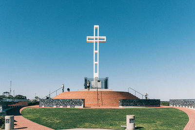 Built structure on field against clear blue sky