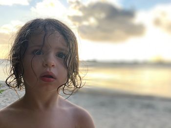 Portrait of shirtless boy at beach against sky