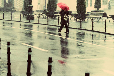 Woman holding umbrella on rainy day