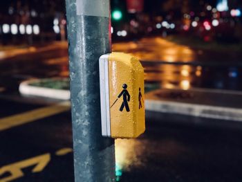 Close-up of sign on pole in city at night