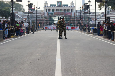 People walking on road along buildings