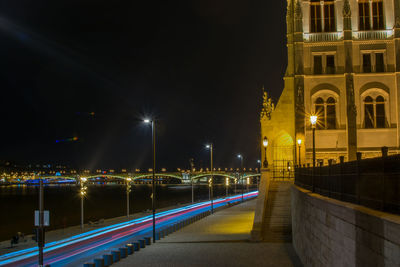 Illuminated light trails on road against sky at night