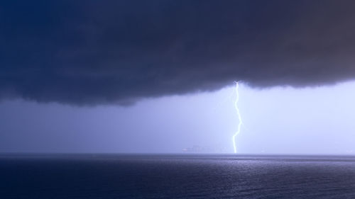 Scenic view of sea against storm clouds