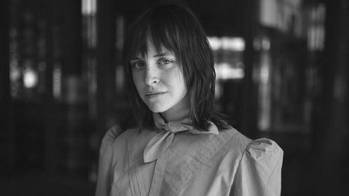 Portrait of young woman standing in darkroom