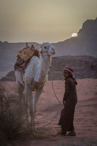 Woman standing on desert against sky