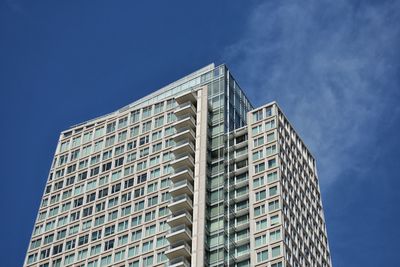 Low angle view of modern building against blue sky